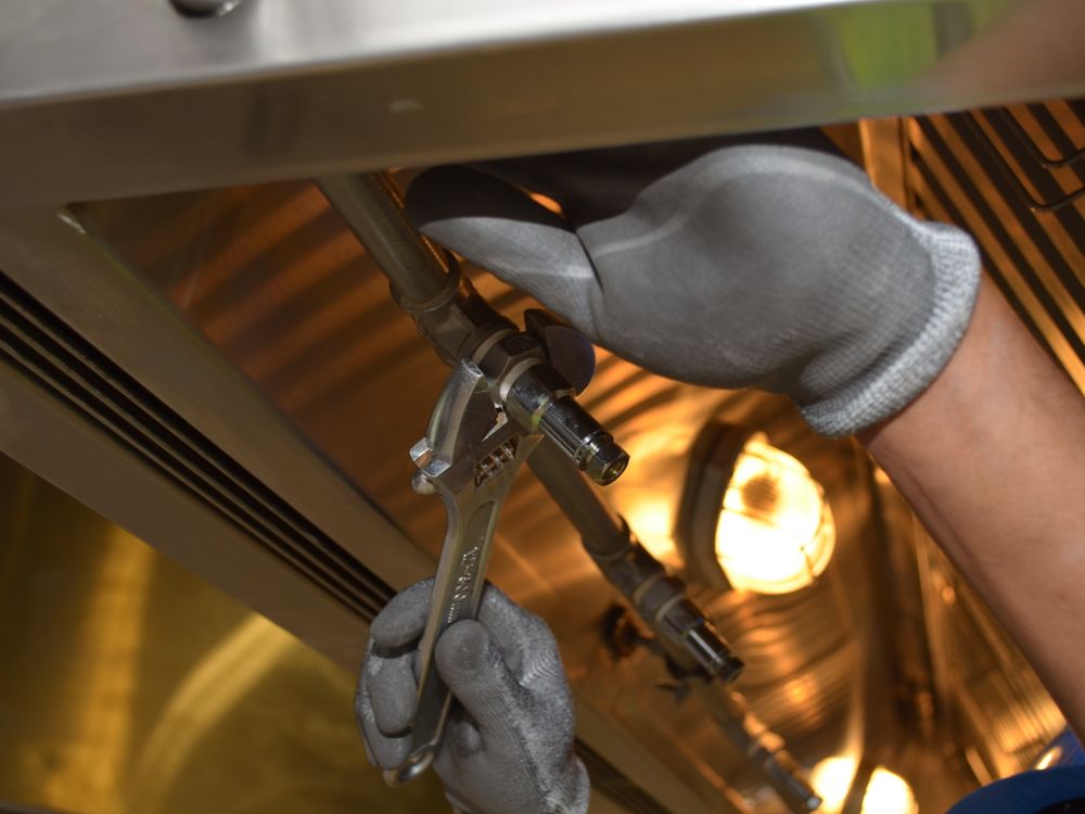 Plumber tightening a pipe fitting with a wrench